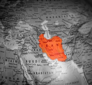America,And,Israel,Have,Started,A,War,Against,Iran.,On A black and white world globe with the country of Iran highlighted in red.