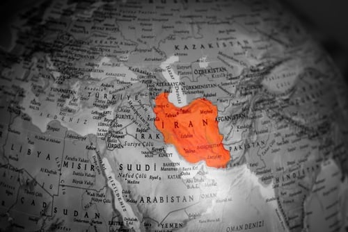 America,And,Israel,Have,Started,A,War,Against,Iran.,On A black and white world globe with the country of Iran highlighted in red.