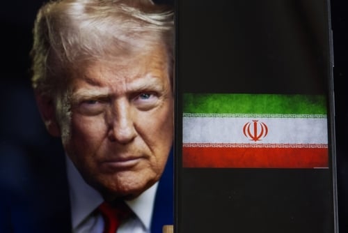 Donald Trump's face with a superimposed image of the Iranian flag on a phone.