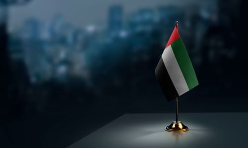 A miniature United Arab Emirates table flag, often used for office desk decorations or diplomatic settings.