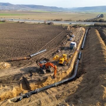 Industrial,Construction,Of,A,Natural,Gas,Pipeline,In,Bulgaria.,Workers An industrial construction site of a natural gas pipeline, with workers and machinery installing large steel pipes.