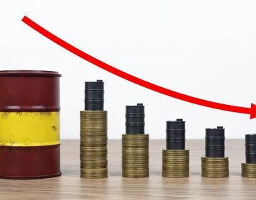 Concept image showing a decline in oil prices with a red arrow pointing downward atop a stacks of coins next to a barrel. Concept image showing a decline in oil prices with a red arrow pointing downward atop a stacks of coins next to a barrel.