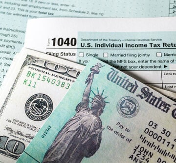 A U.S. Treasury check for a tax refund alongside a Form 1040 for filing individual income taxes.