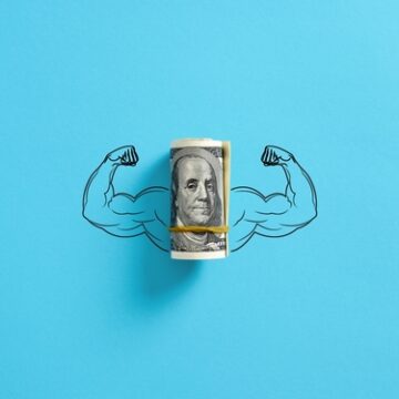 A rolled bunch of dollar bills – specifically showing the $100 note – to act as the core of a muscular arm.