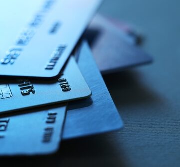 A pile of credit cards against a blue table.