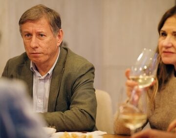 Senior,Friends,Sharing,A,Moment,,Discussing,A,Serious,Topic,,And A group of friends sharing a moment, talking and enjoying glasses of white wine at a social gathering.