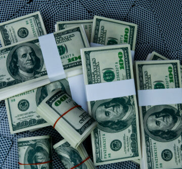 Multiple stacks and rolls of U.S. $100 bills. Multiple stacks and rolls of U.S. $100 bills.