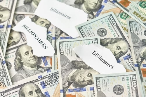 Concept image of a scattered pile of United States $100 bills overlaid with torn scraps of white paper bearing the word "billionaires". Concept image of a scattered pile of United States $100 bills overlaid with torn scraps of white paper bearing the word "billionaires".