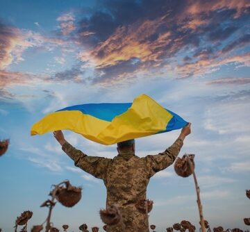 Ukrainian,Soldier,Holds,Ukrainian,Flag,In,Sunflower,Field.,Remembrance,Day UKRAINE WAR MUST GO ON: SENATE COMMITTEE SUPPORTS $750M IN MORE WEAPONS OF DEATH FOR KYIV IN 2027 NDAA