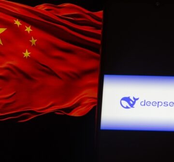 The DeepSeek logo displayed on a smartphone next to a blurred image of the Chinese flag. The DeepSeek logo displayed on a smartphone next to a blurred image of the Chinese flag.