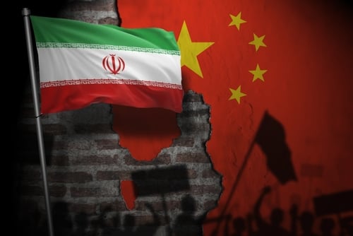 Concept illustration juxtaposes the national flags of Iran and the People's Republic of China over a crumbling brick wall backdrop depicting silhouetted protesters and flags. Concept illustration juxtaposes the national flags of Iran and the People's Republic of China over a crumbling brick wall backdrop depicting silhouetted protesters and flags.