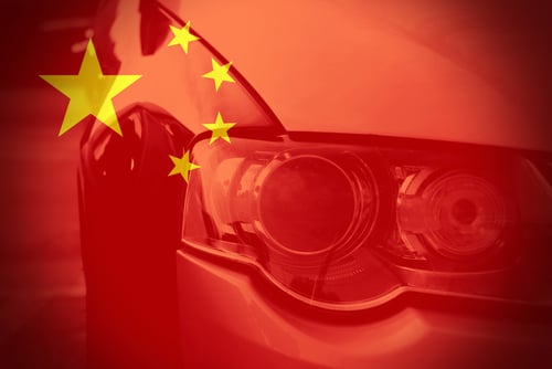 Close-up view of a car headlight overlaid with the Chinese flag.