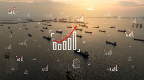 Oil tankers parked in the closed Strait of Hormuz overlaid with icons of rising graphs and oil barrels.
