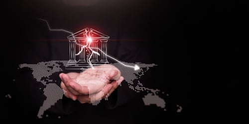 Concept illustration features a businessman's hands holding a cracked bank icon overlaid on a digital world map, with a downward-trending arrow symbolizing recession or market decline. Concept illustration features a businessman's hands holding a cracked bank icon overlaid on a digital world map, with a downward-trending arrow symbolizing recession or market decline.