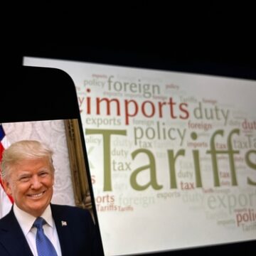 An image of Donald Trump on a mobile phone alongside a word cloud highlighting trade-related terms such as "tariffs," "imports," and "duty."
