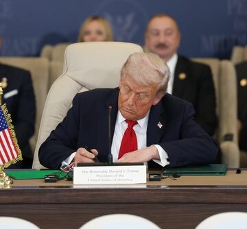 Donald Trump signing documents, likely an executive order. Donald Trump signing documents, likely an executive order.