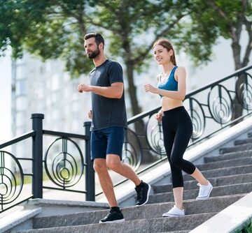 A couple exercising together outdoors on a staircase. A couple exercising together outdoors on a staircase.
