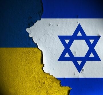 The Ukraine and Israeli flags painted on a wall, both flags separated by a crack. The Ukraine and Israeli flags painted on a wall, both flags separated by a crack.