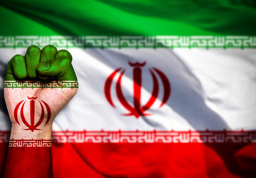 The flag of Iran painted on a male fist – representing the concept of conflict – with the Iranian flag in the background.