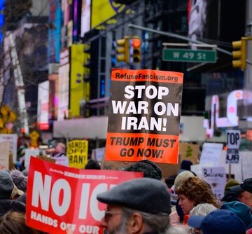 People gathered for a protest in New York City with a sign that reads "STOP WAR ON IRAN!". People gathered for a protest in New York City with a sign that reads "STOP WAR ON IRAN!".