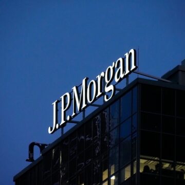 The illuminated JPMorgan corporate logo sitting atop a building at night. The illuminated JPMorgan corporate logo sitting atop a building at night.