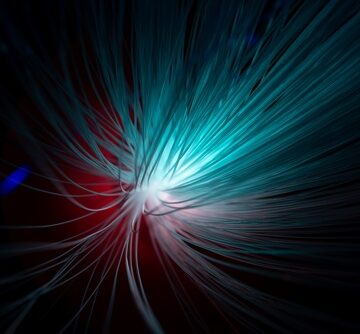 A close-up of fiber optic strands emitting a bright blue and white light burst against a dark background.
