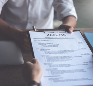 Prospective employee submits resume to interviewer during job interview. Prospective employee submits resume to interviewer during job interview.