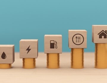 Concept illustration of rising costs and inflation using blocks to symbolize different household expenses, including water, electricity, fuel, food, and housing, and stacking coins indicate increasing prices and the diminishing purchasing power of money. Concept illustration of rising costs and inflation using blocks to symbolize different household expenses, including water, electricity, fuel, food, and housing, and stacking coins indicate increasing prices and the diminishing purchasing power of money.