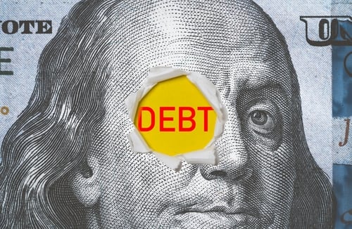 The face of Benjamin Franklin on a $100 bill torn open to reveal the word "DEBT". The face of Benjamin Franklin on a $100 bill torn open to reveal the word "DEBT".