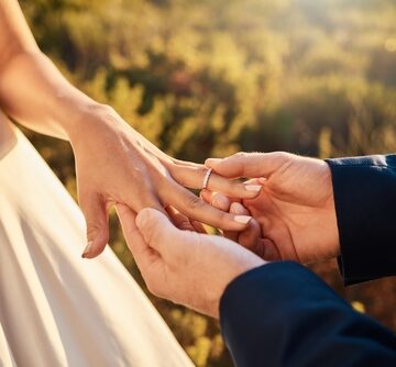 A couple exchanging rings during an outdoor ceremony. A couple exchanging rings during an outdoor ceremony.