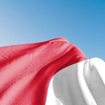 The Indonesian national flag, consisting of two equal horizontal bands of red and white, waving against a bright blue sky. The Indonesian national flag, consisting of two equal horizontal bands of red and white, waving against a bright blue sky.