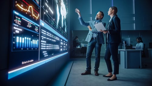 Professionals collaborating in a modern command center or data visualization hub. Professionals collaborating in a modern command center or data visualization hub.