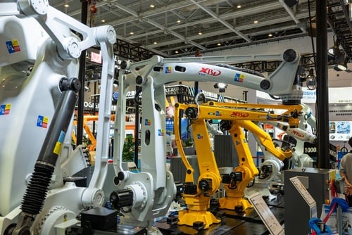 A display of multi-axis industrial robotic arms at a manufacturing and automation technology exhibition, featuring heavy-duty white and yellow articulated robots designed for high-precision assembly, material handling, or welding. A display of multi-axis industrial robotic arms at a manufacturing and automation technology exhibition, featuring heavy-duty white and yellow articulated robots designed for high-precision assembly, material handling, or welding.