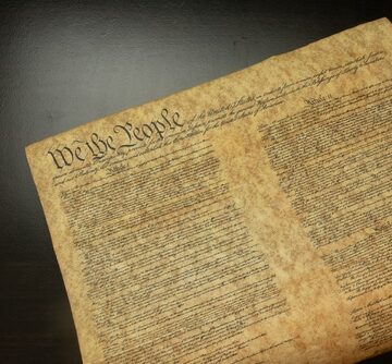 The United States Constitution, featuring the iconic "We the People" preamble, on aged parchment.