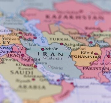A close-up of a political map focusing on Western and Central Asia, with Iran centered prominently in light green, bordered by countries like Iraq, Turkey, Turkmenistan, Afghanistan, and Pakistan.