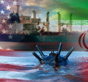 Concept collage showing naval mines deployed in the Strait of Hormuz, overlaying a commercial shipping vessel with the flags of the United States and Iran. Concept collage showing naval mines deployed in the Strait of Hormuz, overlaying a commercial shipping vessel with the flags of the United States and Iran.