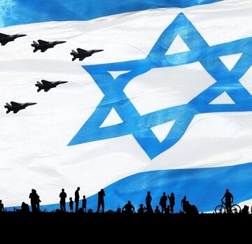 Silhouettes of people and bicycles gathered outdoors against a large national flag of Israel with military fighter jets flying overhead.