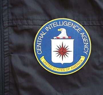 An embroidered patch of the official seal of the United States Central Intelligence Agency (CIA) affixed to a black fabric uniform or jacket.
