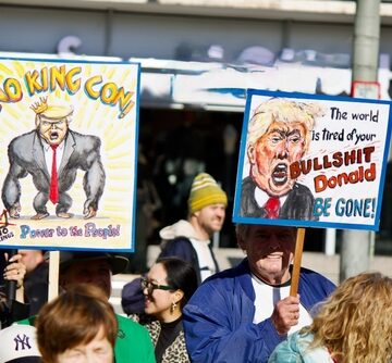 A political rally in Frankfurt, Germany, on October 18, 2025, shows demonstrators holding signs criticizing Donald Trump.