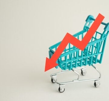 Conceptual image shows a miniature teal shopping cart alongside a downward-pointing red arrow. Conceptual image shows a miniature teal shopping cart alongside a downward-pointing red arrow.