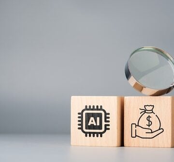 Concept image showing wooden blocks featuring icons for an AI chip and a money bag, signifying the economic impact of AI. Concept image showing wooden blocks featuring icons for an AI chip and a money bag, signifying the economic impact of AI.