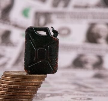 Concept image of a miniature fuel canister sitting on top of a stack of coins to symbolize the rising cost of fuel and its financial strain on consumers. Concept image of a miniature fuel canister sitting on top of a stack of coins to symbolize the rising cost of fuel and its financial strain on consumers.