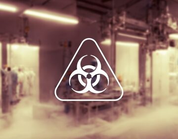 A blurry view of a scientific laboratory overlaid with the standard biohazard symbol. A blurry view of a scientific laboratory overlaid with the standard biohazard symbol.