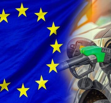 Concept collage of European energy policy, fuel prices, and fossil fuel dependence featuring a fuel nozzle being inserted into a vehicle's fuel tank overlaid against the background of the European Union flag. Concept collage of European energy policy, fuel prices, and fossil fuel dependence featuring a fuel nozzle being inserted into a vehicle's fuel tank overlaid against the background of the European Union flag.