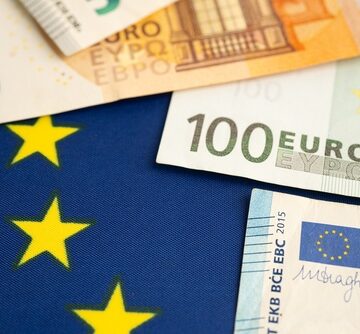 50- and 100-Euro banknotes placed on the flag of the European Union. 50- and 100-Euro banknotes placed on the flag of the European Union.
