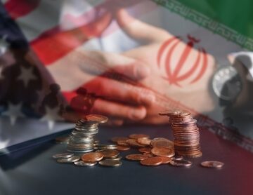 Concept image depicting U.S. and Iranian flags, a handshake, and stacked coins or currency. Concept image depicting U.S. and Iranian flags, a handshake, and stacked coins or currency.