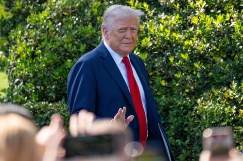 President Donald Trump gesturing toward reporters on the South Lawn of the White House.