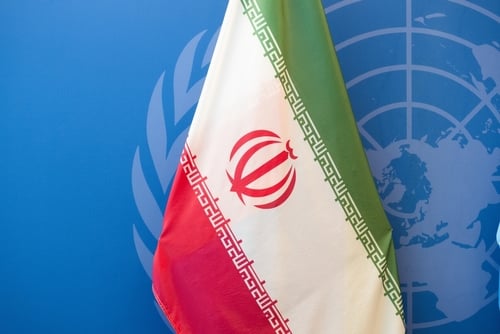 The national flag of Iran displayed in front of the United Nations emblem. The national flag of Iran displayed in front of the United Nations emblem.