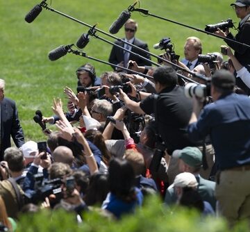 President Donald Trump speaking with reporters and photographers on the South Lawn of the White House.