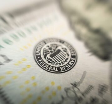 A close-up of the Federal Reserve System emblem printed on a United States one-hundred-dollar banknote. A close-up of the Federal Reserve System emblem printed on a United States one-hundred-dollar banknote.